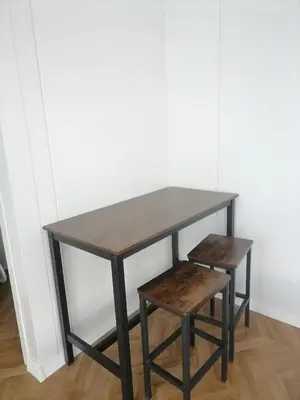 a wooden table with a bench and a table and stool at Pas Alksnius in Šiaudinė