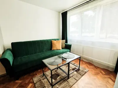 a living room with a green couch and a table at Cozy A Noko Apartment in Murava