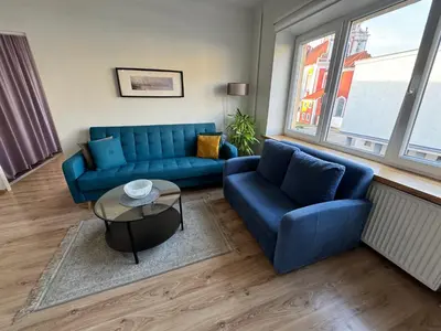 a living room with a blue couch and a table at Spacious apartment in Old Town Vilnius street in Vilnius