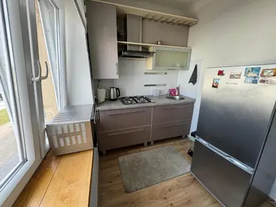 a small kitchen with a stainless steel refrigerator at Spacious apartment in Old Town Vilnius street in Vilnius