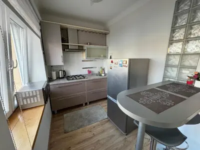 a small kitchen with a table and a refrigerator at Spacious apartment in Old Town Vilnius street in Vilnius