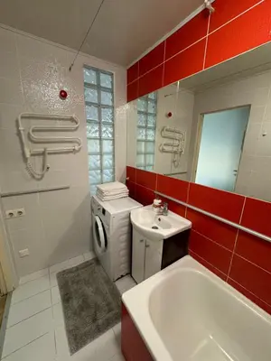 a bathroom with a white sink and a washing machine at Spacious apartment in Old Town Vilnius street in Vilnius