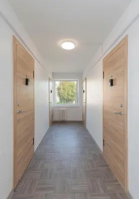an empty hallway with wooden doors and a window at Pramonės apartment #2 by PoloApartments in Kaunas