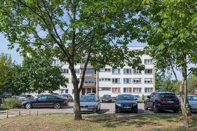 a parking lot with cars parked in front of a building at Pramonės apartment #2 by PoloApartments in Kaunas