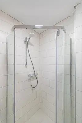 a shower with a glass door in a bathroom at Pramonės Apartment #5 by PoloApartments in Kaunas