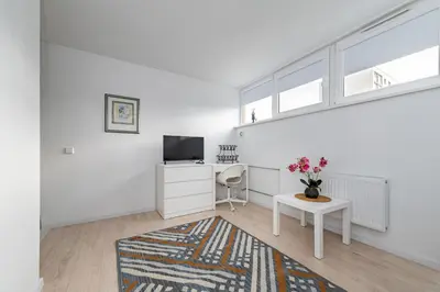 a white apartment with a desk and a tv at Pramonės Apartment #5 by PoloApartments in Kaunas