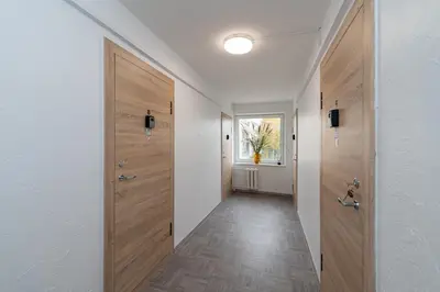 a hallway with wooden doors and a hallway with a window at Pramonės Apartment #5 by PoloApartments in Kaunas