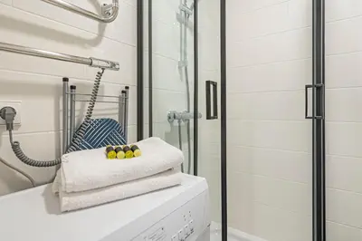 a bathroom with a shower and three towels at Pramonės Apartment #7 by PoloApartments in Kaunas