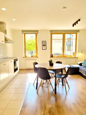 a kitchen and living room with a table and chairs at Sv1 Amber Oldtown SELF CHECK-IN by QuarterStays in Vilnius