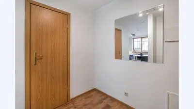 a hallway with a wooden door and a mirror at Sv1 Amber Oldtown SELF CHECK-IN by QuarterStays in Vilnius