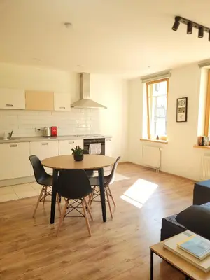 a kitchen and living room with a table and chairs at Sv1 Amber Oldtown SELF CHECK-IN by QuarterStays in Vilnius