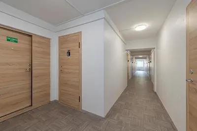 an empty hallway with wooden doors and a corridor at Pramonės Apartment #8 by PoloApartments in Kaunas