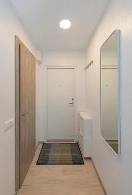 a hallway with a white door and a mirror at Pramonės Apartment #8 by PoloApartments in Kaunas
