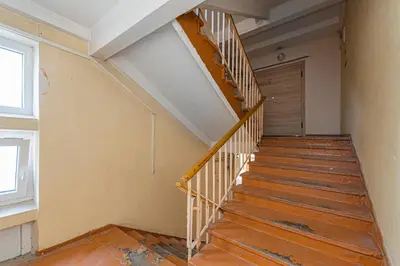 an empty room with a wooden staircase with a door at Pramonės Apartment #9 by PoloApartments in Kaunas