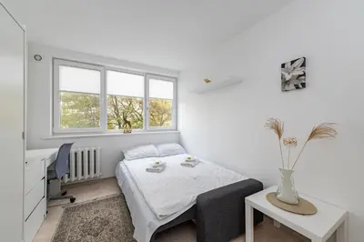 a bedroom with a bed and a desk and window at Pramonės Apartment #9 by PoloApartments in Kaunas