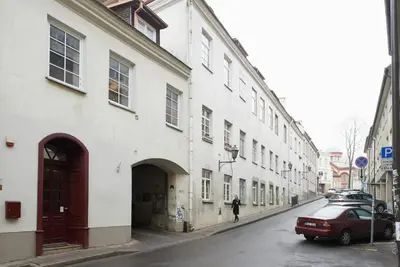 a person walking down a street next to a white building at Elegant apartment in Old town Vilnius SELF CHECK IN 24x7 by H&H in Vilnius