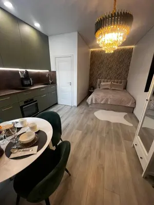 a living room with a dining room table and a bed at Chic Residence apartament 1 in Šiauliai
