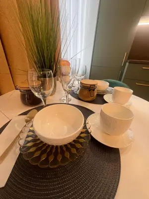 a table with plates and bowls and glasses on it at Chic Residence apartament 1 in Šiauliai