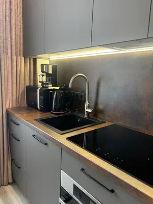 a kitchen counter with a sink and a microwave at Chic Residence apartament 2 in Šiauliai