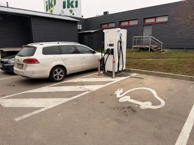a white car parked next to a gas pump at Chic Residence apartament 2 in Šiauliai
