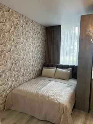 a bedroom with a large bed with a stone wall at Chic Residence apartament 2 in Šiauliai