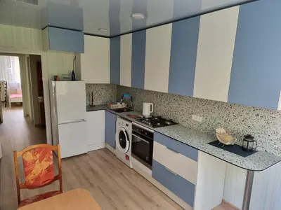 a kitchen with blue and white cabinets and a stove top oven at Kaunas 174 in Murava