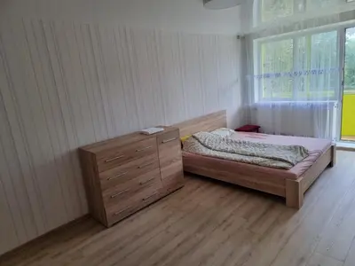 a bedroom with a bed and a dresser and a window at Kaunas 174 in Murava