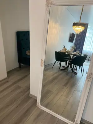 a mirror in a dining room with a table and chairs at Chic Residence apartament 3 in Šiauliai