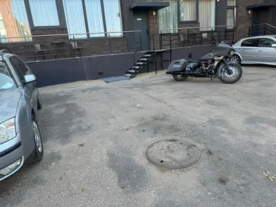 a motorcycle parked in a parking lot next to a car at Chic Residence apartament 3 in Šiauliai