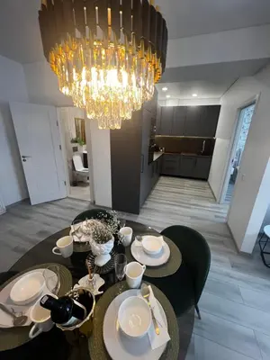a dining room with a table with a chandelier at Chic Residence apartament 3 in Šiauliai