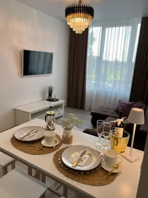 a living room with a table with plates and silverware at Chic Residence apartament 4 in Šiauliai
