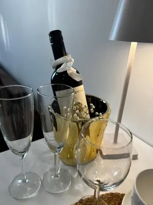 a bottle of wine and two glasses on a table at Chic Residence apartament 4 in Šiauliai