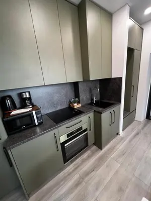 a kitchen with white cabinets and a counter top at Chic Residence apartament 4 in Šiauliai