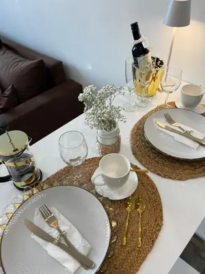 a white table with plates and silverware on it at Chic Residence apartament 4 in Šiauliai