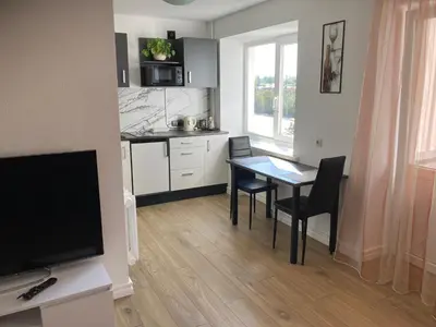a small kitchen with a table and a dining room at White & Black in Šiauliai