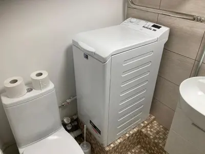 a white bathroom with a toilet and a sink at White & Black in Šiauliai