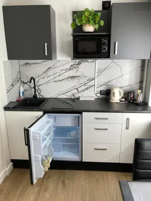 a kitchen with a black counter top and a sink at White & Black in Šiauliai