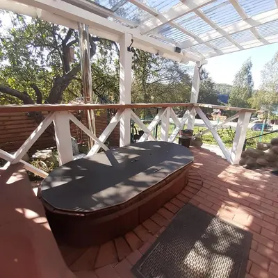 a hot tub sitting under a pergola on a patio at Dvivietis namelis su ofuro vone in Esperanza