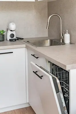 a kitchen with white cabinets and a sink at Loft G57 in Vilnius