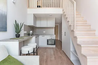a kitchen with white cabinets and a staircase at Loft G57 in Vilnius