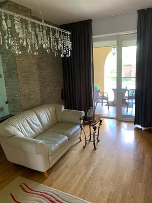 a living room with a couch and a chandelier at Green Garden Apartments in Kaunas