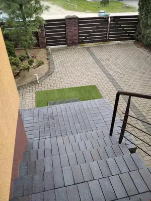 a brick walkway with a metal rail and grass at Green Garden Apartments in Kaunas
