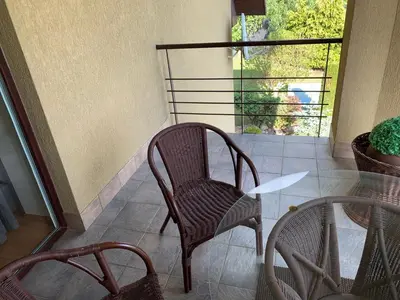 a patio with two chairs and a table and a window at Green Garden Apartments in Kaunas