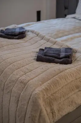 two towels sitting on top of a bed at Old Town - Bajor Studios - Self Check-in and Parking in Kaunas