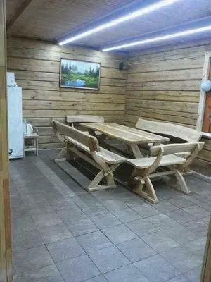 a room with a table and benches in a cabin at Pirtis su kubilu ant ežero kranto Birvarelax in Kariotiškės