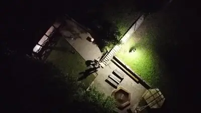 an overhead view of a building with a person standing in the grass at Pirtis su kubilu ant ežero kranto Birvarelax in Kariotiškės