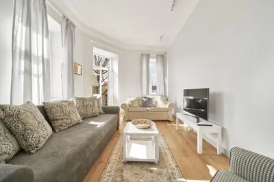 a living room with a couch and a tv at Cute&Light Apartment, Vilnius City Centre in Vilnius
