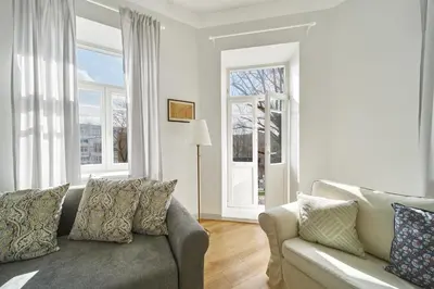 a living room with a couch and two windows at Cute&Light Apartment, Vilnius City Centre in Vilnius