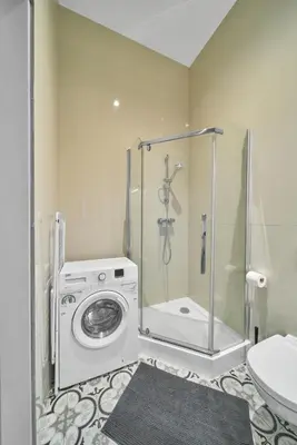 a bathroom with a washing machine and a shower at Cute&Light Apartment, Vilnius City Centre in Vilnius