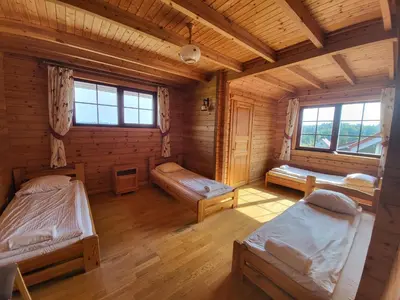 a room with two beds in a log cabin at Vytauto kaimas - Didelis namas in Aukštadvaris